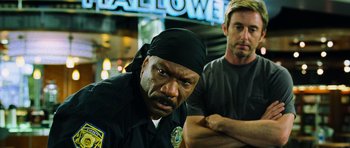 Movie still from “Dawn of the Dead” (2004), directed by Zack Snyder – Two police officers standing next to each other in front of a building; Close Up shot, Low angle