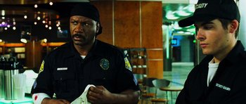 Movie still from “Dawn of the Dead” (2004), directed by Zack Snyder – A man in a police uniform holding a napkin; Close Up shot, Over the shoulder angle