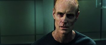 Movie still from “Dawn of the Dead” (2004), directed by Zack Snyder – A person wearing a black t - shirt; Close Up shot, Low angle