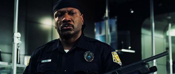 Movie still from “Dawn of the Dead” (2004), directed by Zack Snyder – A man in a black police uniform looking at the camera; Close Up shot, Low angle
