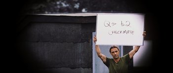 Movie still from “Dawn of the Dead” (2004), directed by Zack Snyder – A man holding up a sign that says " q >= less checks "; Medium shot, Over the shoulder angle