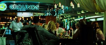 Movie still from “Dawn of the Dead” (2004), directed by Zack Snyder – A group of people sitting around a table with candles; Wide shot, Over the shoulder angle