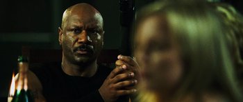 Movie still from “Dawn of the Dead” (2004), directed by Zack Snyder – A bald man holding a gun in front of a mirror; Close Up shot, Low angle