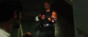 Movie still from “Dawn of the Dead” (2004), directed by Zack Snyder – A man in black shirt holding a video game controller; Medium shot, Low angle