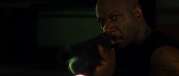 Movie still from “Dawn of the Dead” (2004), directed by Zack Snyder – A person holding a gun in a dark room; Close Up shot, Low angle