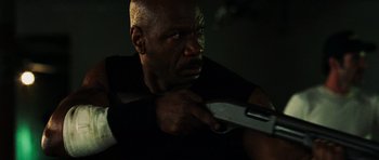 Movie still from “Dawn of the Dead” (2004), directed by Zack Snyder – A man holding a wrench in a dark room; Close Up shot, Low angle