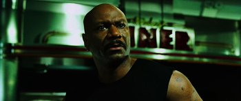 Movie still from “Dawn of the Dead” (2004), directed by Zack Snyder – A man with a bald head looking into the distance; Close Up shot, Low angle