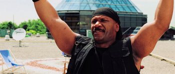 Movie still from “Dawn of the Dead” (2004), directed by Zack Snyder – A man with a black bandana on his head is waving; Close Up shot, Low angle