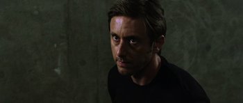 Movie still from “Dawn of the Dead” (2004), directed by Zack Snyder – A person wearing a black t - shirt; Close Up shot, Over the shoulder angle