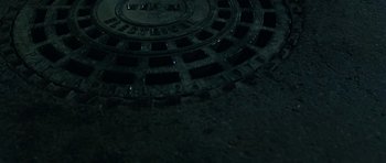 Movie still from “Dawn of the Dead” (2004), directed by Zack Snyder – A manhole cover in the middle of the night; Extreme Close Up shot, Overhead angle