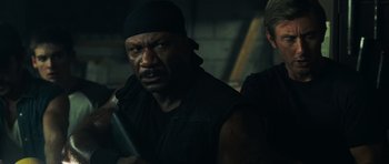 Movie still from “Dawn of the Dead” (2004), directed by Zack Snyder – A person holding a gun in a dark room; Close Up shot, Over the shoulder angle