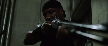 Movie still from “Dawn of the Dead” (2004), directed by Zack Snyder – A man is holding a gun in a dark room; Close Up shot, Low angle