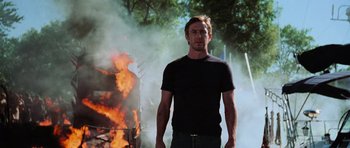 Movie still from “Dawn of the Dead” (2004), directed by Zack Snyder – A man standing in front of a fire; Medium shot, Low angle