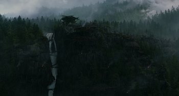 Movie still from “Dawn of the Planet of the Apes” (2014), directed by Matt Reeves – A helicopter flying over a waterfall on a rainy day; Extreme Wide shot, High angle