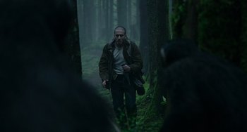 Movie still from “Dawn of the Planet of the Apes” (2014), directed by Matt Reeves – A man walking through the woods in the rain; Medium shot, Low angle