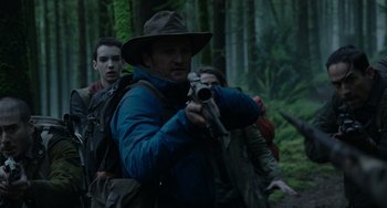 Movie still from “Dawn of the Planet of the Apes” (2014), directed by Matt Reeves – A group of people walking through a forest; Medium shot, Over the shoulder angle