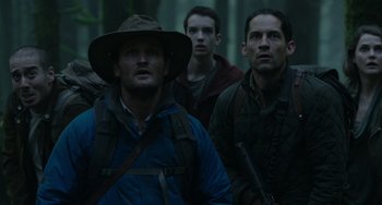 Movie still from “Dawn of the Planet of the Apes” (2014), directed by Matt Reeves – A group of men standing next to each other in the woods; Medium shot, Low angle