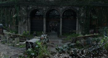 Movie still from “Dawn of the Planet of the Apes” (2014), directed by Matt Reeves – A group of people standing in front of an old building; Extreme Wide shot, High angle