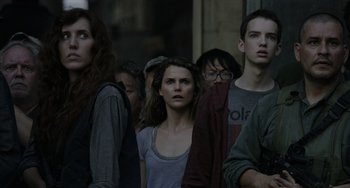 Movie still from “Dawn of the Planet of the Apes” (2014), directed by Matt Reeves – A group of people standing next to each other on the street; Close Up shot, Over the shoulder angle