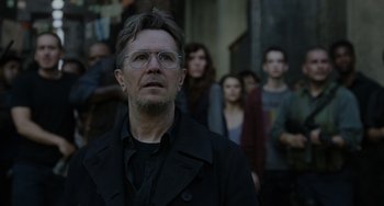 Movie still from “Dawn of the Planet of the Apes” (2014), directed by Matt Reeves – A group of people standing around a man in a black jacket; Close Up shot, Over the shoulder angle