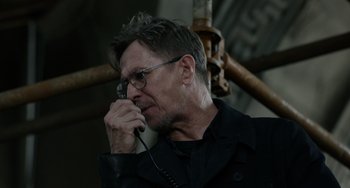 Movie still from “Dawn of the Planet of the Apes” (2014), directed by Matt Reeves – A man with glasses is talking on a phone; Close Up shot, Low angle