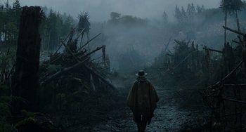 Movie still from “Dawn of the Planet of the Apes” (2014), directed by Matt Reeves – A man in a rain coat walking through a forest; Extreme Wide shot, Low angle