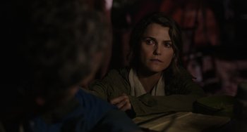 Movie still from “Dawn of the Planet of the Apes” (2014), directed by Matt Reeves – A woman sitting in front of a man in front of a table; Close Up shot, Over the shoulder angle