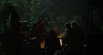 Movie still from “Dawn of the Planet of the Apes” (2014), directed by Matt Reeves – A group of people gathered around a fire in the dark; Wide shot, Over the shoulder angle
