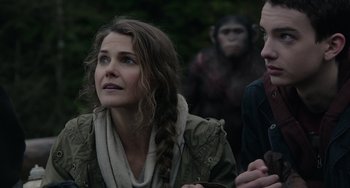 Movie still from “Dawn of the Planet of the Apes” (2014), directed by Matt Reeves – A woman with a braid looking up at a monkey; Close Up shot, Low angle