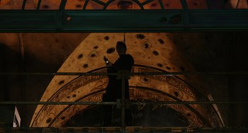 Movie still from “Dawn of the Planet of the Apes” (2014), directed by Matt Reeves – A man standing in front of a building with a laptop; Wide shot, Low angle