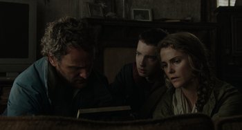 Movie still from “Dawn of the Planet of the Apes” (2014), directed by Matt Reeves – A man and two young men looking at a book; Close Up shot, Low angle