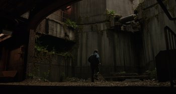 Movie still from “Dawn of the Planet of the Apes” (2014), directed by Matt Reeves – A man walking in front of an abandoned building; Extreme Wide shot, Low angle