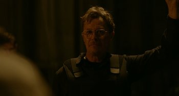 Movie still from “Dawn of the Planet of the Apes” (2014), directed by Matt Reeves – A man with glasses is wearing a black shirt; Close Up shot, Over the shoulder angle