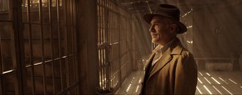 Movie still from “Dead for a Dollar” (2022), directed by Walter Hill – A man in a hat looking out of a jail cell; Medium shot, Low angle