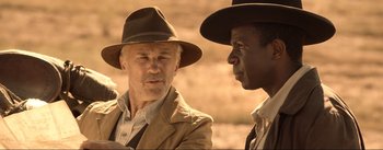 Movie still from “Dead for a Dollar” (2022), directed by Walter Hill – A man in a hat talking to another man in a hat; Close Up shot, Over the shoulder angle