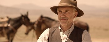 Movie still from “Dead for a Dollar” (2022), directed by Walter Hill – An older man wearing a hat and a vest; Close Up shot, Low angle