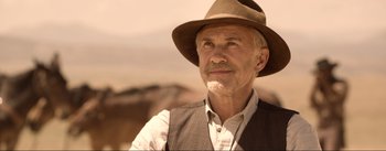 Movie still from “Dead for a Dollar” (2022), directed by Walter Hill – An older man wearing a hat and a vest; Close Up shot, Low angle
