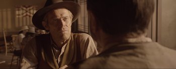 Movie still from “Dead for a Dollar” (2022), directed by Walter Hill – An older man wearing a cowboy hat talking to a younger man; Close Up shot, Over the shoulder angle