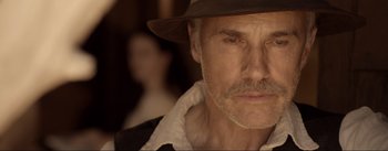 Movie still from “Dead for a Dollar” (2022), directed by Walter Hill – A person wearing a hat and looking at the camera; Close Up shot, Low angle
