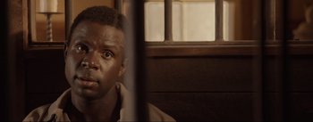 Movie still from “Dead for a Dollar” (2022), directed by Walter Hill – A person behind a fence; Close Up shot, Over the shoulder angle