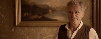 Movie still from “Dead for a Dollar” (2022), directed by Walter Hill – A man standing in front of a painting in a room; Close Up shot, Over the shoulder angle