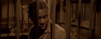Movie still from “Dead for a Dollar” (2022), directed by Walter Hill – A black man in a jail cell with his eyes wide open; Close Up shot, High angle
