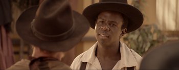 Movie still from “Dead for a Dollar” (2022), directed by Walter Hill – A man wearing a brown hat and a white shirt; Close Up shot, Over the shoulder angle