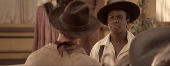 Movie still from “Dead for a Dollar” (2022), directed by Walter Hill – A man in a cowboy hat is looking at another man in a cowboy hat; Close Up shot, Over the shoulder angle