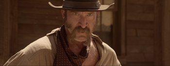 Movie still from “Dead for a Dollar” (2022), directed by Walter Hill – A person wearing a cowboy hat; Close Up shot, Over the shoulder angle
