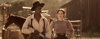 Movie still from “Dead for a Dollar” (2022), directed by Walter Hill – A man and a woman standing next to each other holding guns; Medium shot, Over the shoulder angle