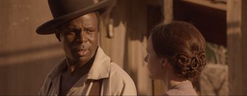 Movie still from “Dead for a Dollar” (2022), directed by Walter Hill – A man and a woman are standing next to each other; Close Up shot, Over the shoulder angle