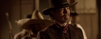 Movie still from “Dead for a Dollar” (2022), directed by Walter Hill – A man in a suit and a top hat; Close Up shot, Over the shoulder angle