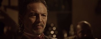 Movie still from “Dead for a Dollar” (2022), directed by Walter Hill – A person wearing a suit and tie; Close Up shot, Over the shoulder angle