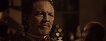 Movie still from “Dead for a Dollar” (2022), directed by Walter Hill – A person wearing a suit and tie; Close Up shot, Over the shoulder angle